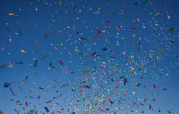Confetti flying in the air against a blue sky