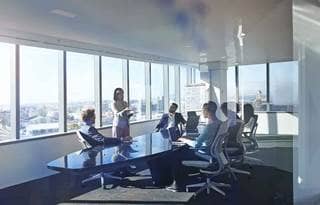Business professionals in a conference room having a meeting sitting at a conference table.