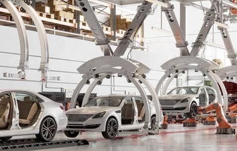 Cars on a factory assembly line.