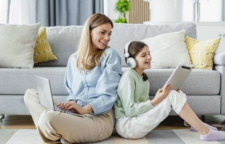 Parent sitting on the floor with their child and learning about how school districts can proactively manage cyber risk to protect student data.