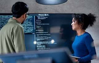 Technology professionals looking at lines of code.