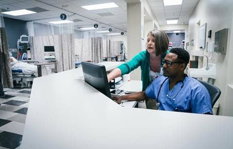 Medical professionals looking at their computer.