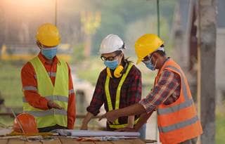 Construction workers wearing protective facemasks.