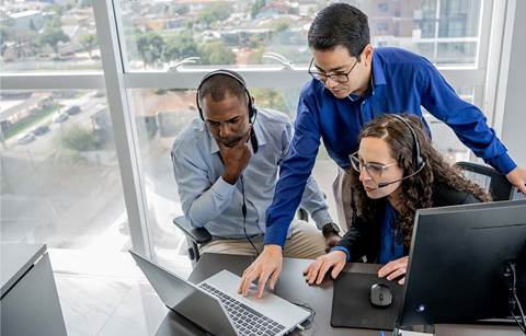 Group of cybersecurity professionals gathered around a computer.