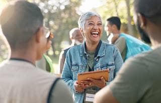 Older woman religious volunteering with a varioety of others of all ages