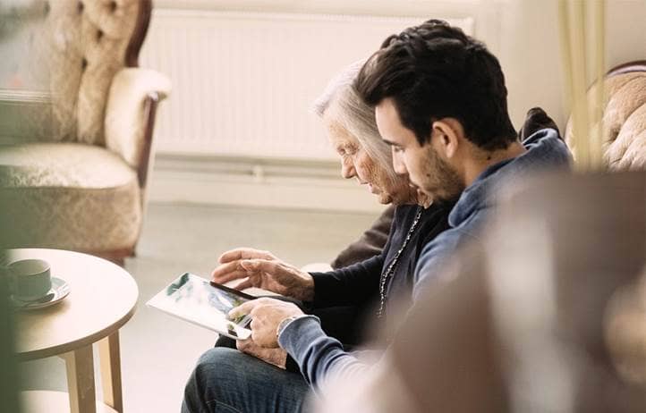 Senior mother looking at a clipboard with adult son