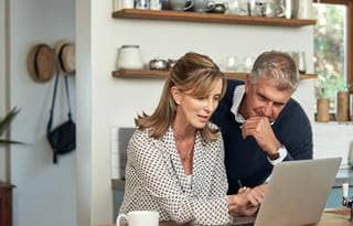 Couple on their laptop computer planning for their year end finances.